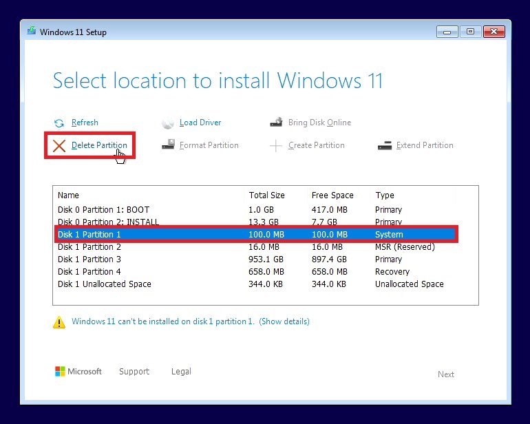 Windows 11 Setup drive selection screen showing existing partitions from a previous installation with the Delete Partition option